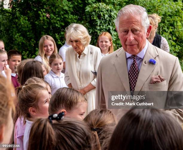 Prince Charles, Prince of Wales and Camilla, Duchess of Cornwall talk to some local children during a visit to Llandovery Train Station on July 4,...