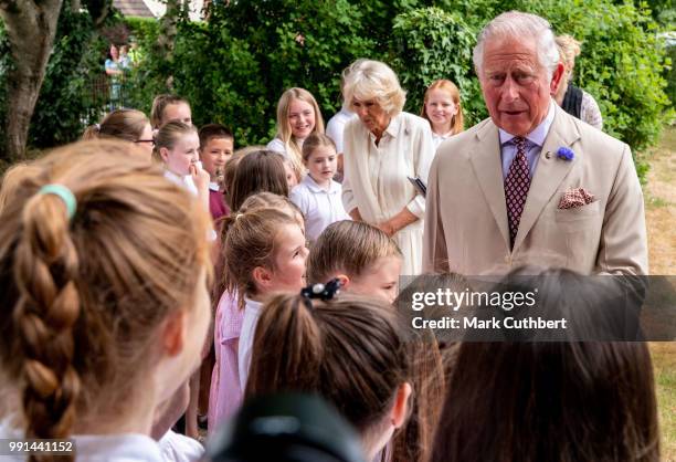 Prince Charles, Prince of Wales and Camilla, Duchess of Cornwall talk to some local children during a visit to Llandovery Train Station on July 4,...