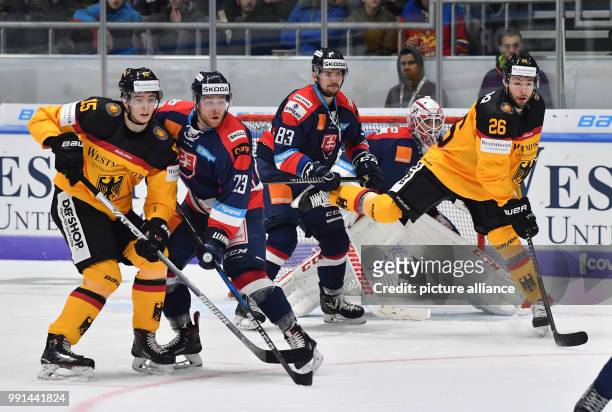Germany's Stefan Loibl and Andreas Eder vying for the puck against Slovkia's Adam Janosik , Martin Bakos and goalkeeper Patrik Rybar during the...