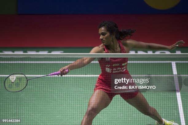 Sindhu Pusarla of India hits a return against Pornpawee Chochuwong of Thailand during their women's singles badminton match at the Indonesia Open in...