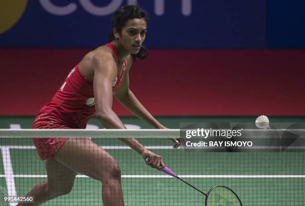 Sindhu Pusarla of India hits a return against Pornpawee Chochuwong of Thailand during their women's singles badminton match at the Indonesia Open in...