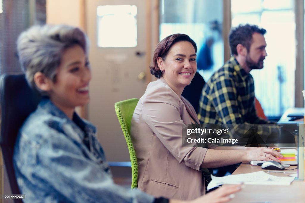 Portrait confident, creative businesswoman working in open plan office