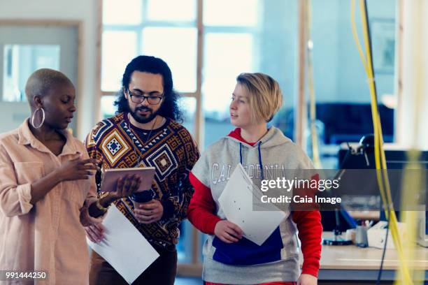 creative business people using digital tablet in office - vanguardista fotografías e imágenes de stock
