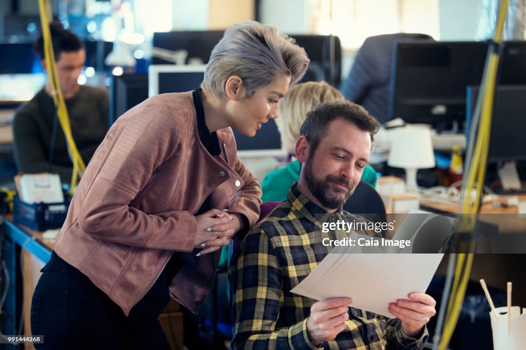 Creative business people discussing paperwork in office