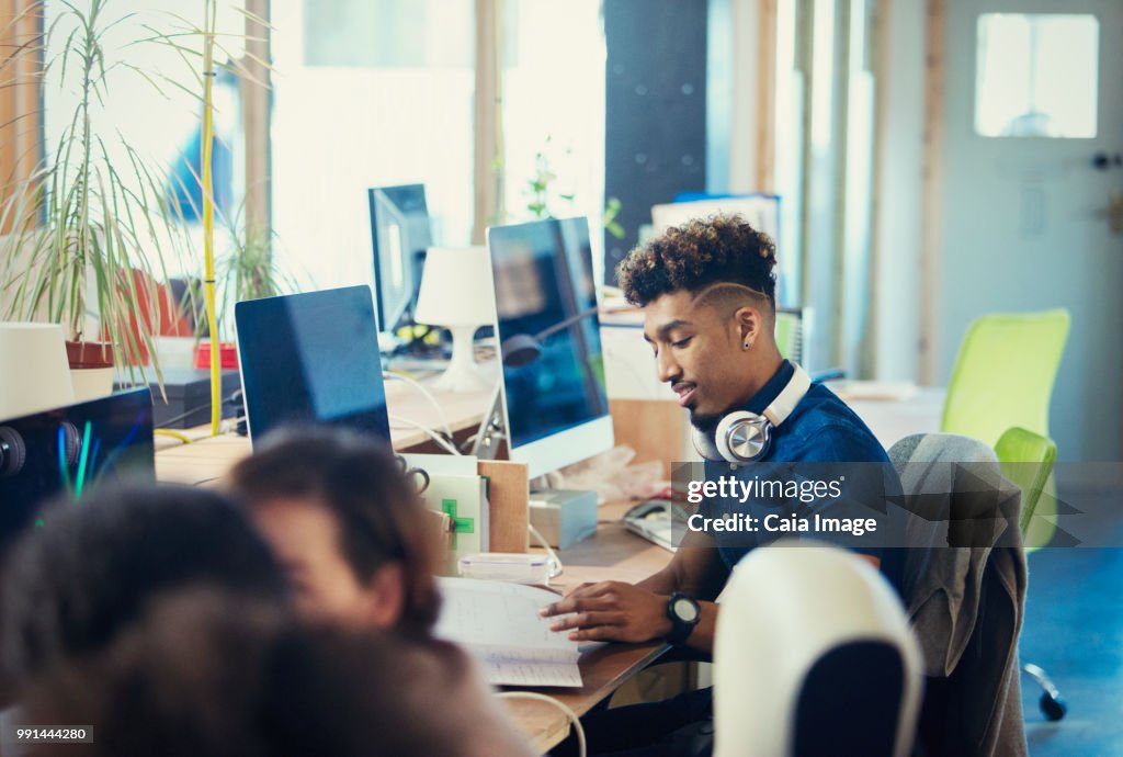 Creative businessman working at computer in open plan office