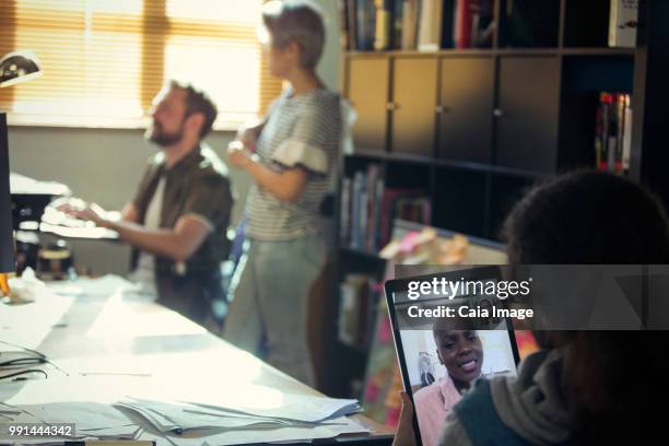 creative businessman video chatting with colleague on digital tablet in office - vanguardians stock-fotos und bilder