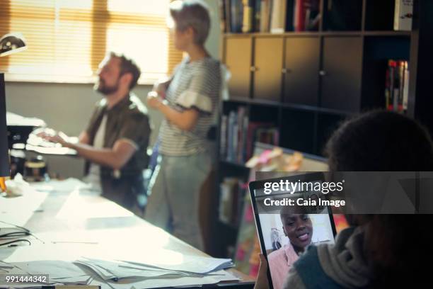 creative businessman video chatting with colleague on digital tablet in office - crowdsourcing imagens e fotografias de stock