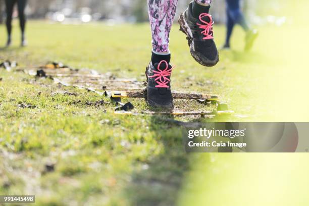 woman doing speed ladder drill in sunny park - agility ladder ストックフォトと画像