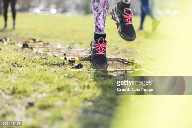 woman doing speed ladder drill in sunny park - agility ladder stock pictures, royalty-free photos & images