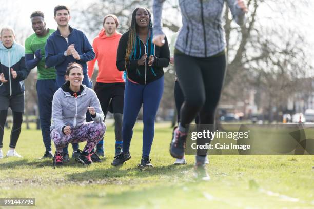 team cheering woman doing speed ladder drill in sunny park - agility ladder stock pictures, royalty-free photos & images