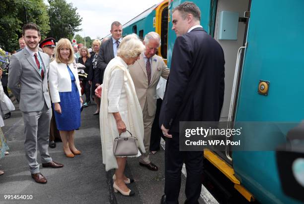 Prince Charles, Prince of Wales helps Camilla, Duchess of Cornwall board a train after they mark the 150th anniversary of the Heart of Wales railway...