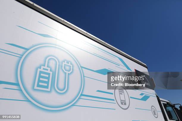 Battery and plug symbol sit on the trailer of a MAN SE TGW eTruck freight vehicle during an electric powered driving demonstration at Berlin...