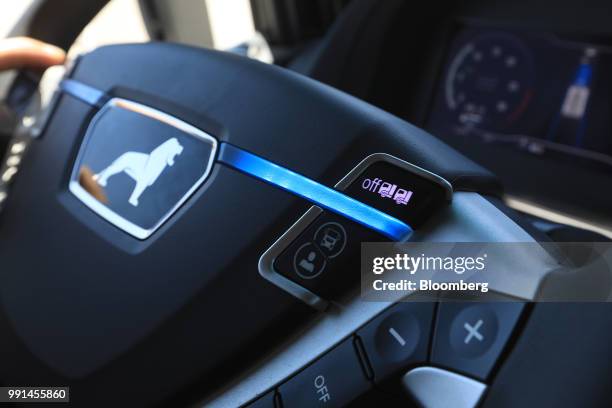 Operating switches sit on a steering wheel control panel of a MAN SE TGX freight truck during a wireless communication technology "platooning" test...