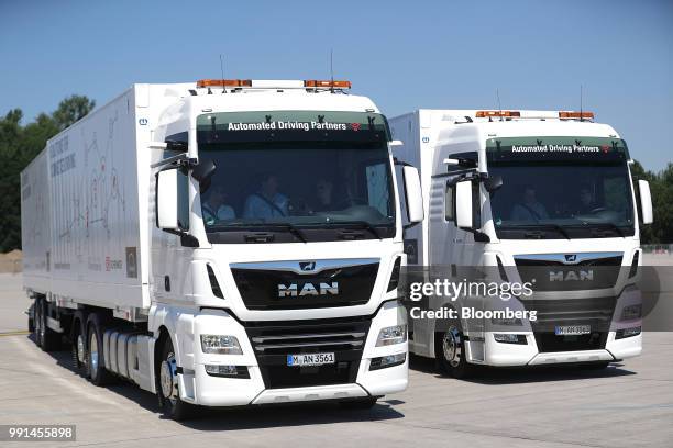 Pair of MAN SE TGX freight trucks stand during a wireless communication technology "platooning" test drive at Berlin ExpoCenter airport exhibition...