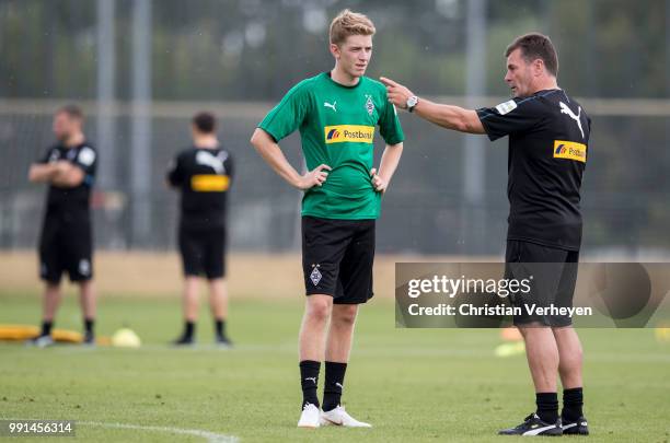 Head Coach Dieter Hecking talks to Andreas Poulsen during a training session of Borussia Moenchengladbach at Borussia-Park on July 04, 2018 in...