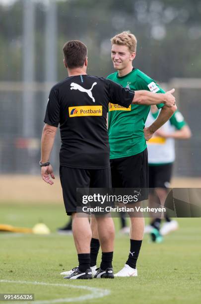 Head Coach Dieter Hecking talks to Andreas Poulsen during a training session of Borussia Moenchengladbach at Borussia-Park on July 04, 2018 in...