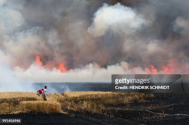 Fireworkers trie to extinguish a fire on a field that broke out due to ongoing drought in Brehna, on July 4, 2018. / Germany OUT