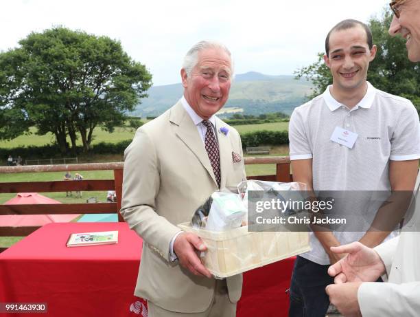 Prince Charles, Prince of Wales receives gifts as he celebrates the 60th Anniversary of the designation of the Brecon Beacons National Park at the...