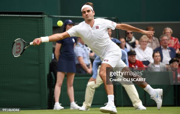 Switzerland's Roger Federer returns against Slovakia's Lukas Lacko during their men's singles second round match on the third day of the 2018...