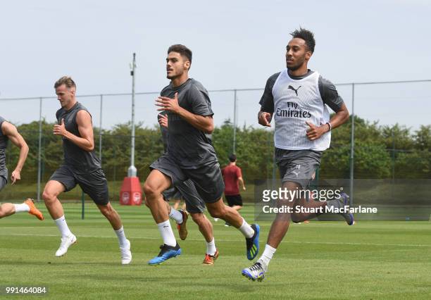 Rob Holding, Konstantinos Mavropanos and Pierre-Emerick Aubameyang of Arsenal run during a training session at London Colney on July 4, 2018 in St...