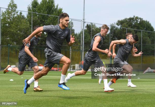 Konstantinos Mavropanos and Rob Holding of Arsenal runs during a training session at London Colney on July 4, 2018 in St Albans, England.