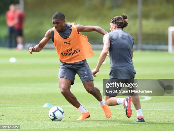 Chuba Akpom and Hector Bellerin of Arsenal fight for the ball during a training session at London Colney on July 4, 2018 in St Albans, England.