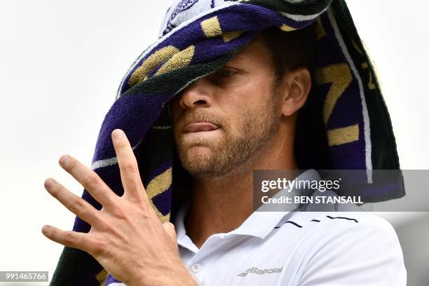 Player Ryan Harrison uses a towel during a break in play against France's Adrian Mannarino during their men's singles second round match on the third...