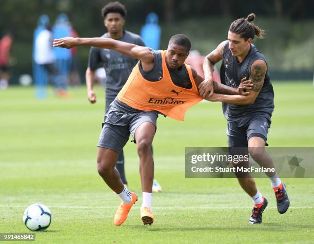 Chuba Akpom and Hector Bellerin of Arsenal fight for the ball during a training session at London Colney on July 4, 2018 in St Albans, England.