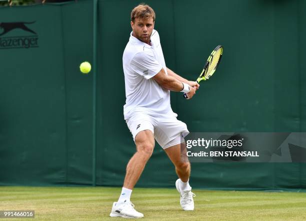 Player Ryan Harrison returns against France's Adrian Mannarino during their men's singles second round match on the third day of the 2018 Wimbledon...