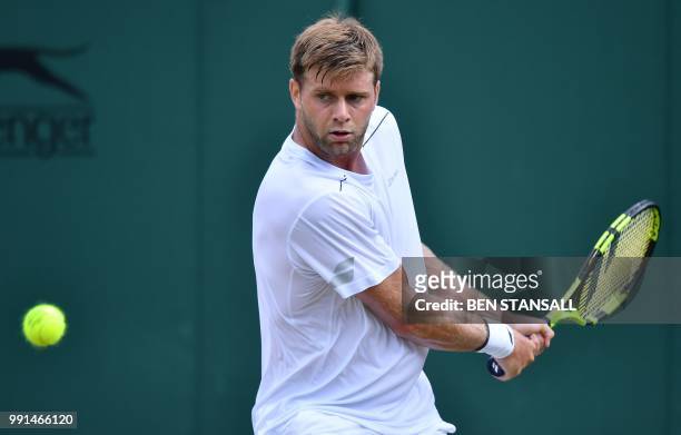 Player Ryan Harrison returns against France's Adrian Mannarino during their men's singles second round match on the third day of the 2018 Wimbledon...