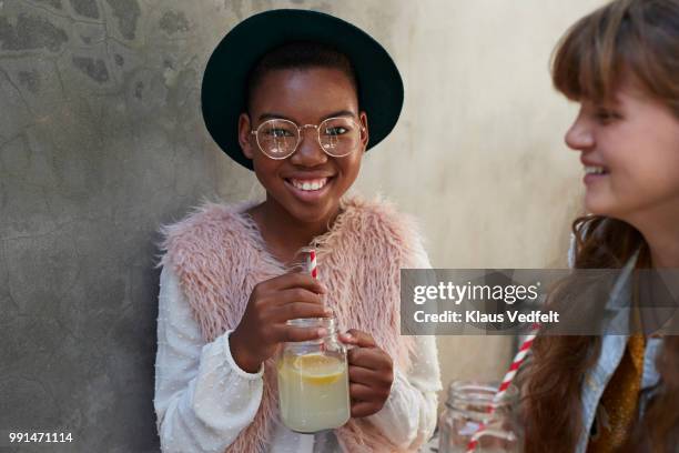 girls sitting on staircase & drinking lemonade - black girl stock-fotos und bilder