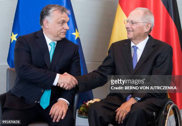 President of the Bundestag Wolfgang Schaeuble and Hungary's Prime Minister Viktor Orban shake hands during a meeting in Berlin, on July 4, 2018. /...