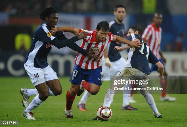 Sergio Aguero of Atletico Madrid is challenged by Zoltan Gera and Dickson Etuhu of Fulham during the UEFA Europa League final match between Atletico...
