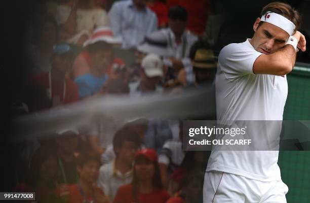 Fans of Switzerland's Roger Federer are reflected in a television camera as he plays against Slovakia's Lukas Lacko during their men's singles second...