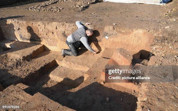 Rolf Skrypzak, excavation technician at the Monuments Office Frankfurt, works on an archaeological site in the district of Heddernheim in Frankfurt...