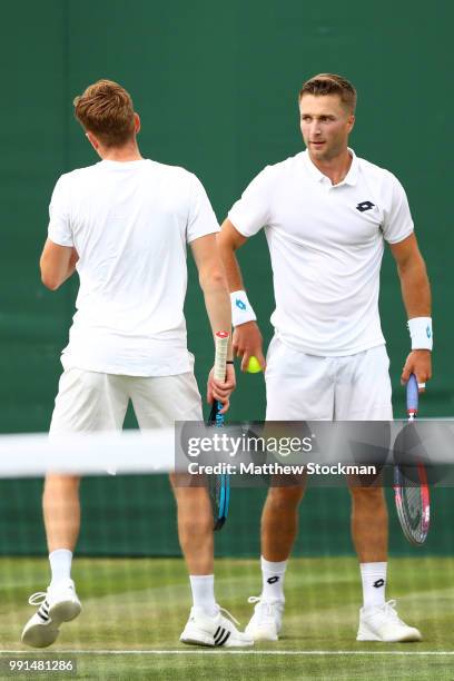 Scott Clayton and Liam Broady of Great Britain talk during their Men's Doubles first round match Frances Tiafoe and Jackson Withrow of the United...