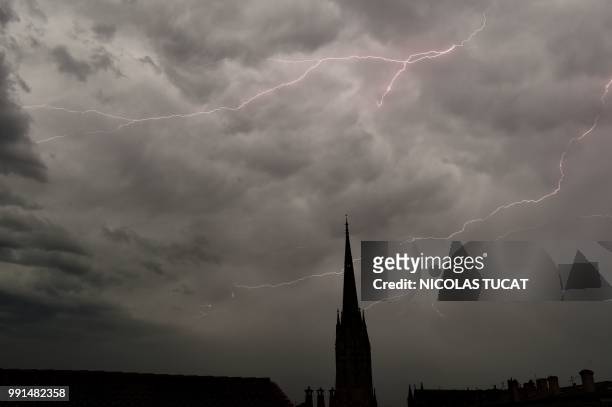Lightning flashes illuminate the sky over the Saint-Michel church in Bordeaux, southwestern France, on July 4, 2018.