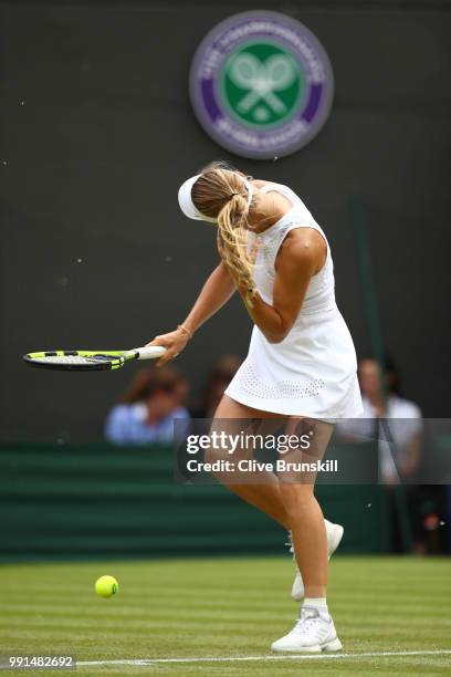 Flying ants cause Caroline Wozniacki of Denmark to shake her hair as she attempts to serve against Ekaterina Makarova of Russia during their Ladies'...