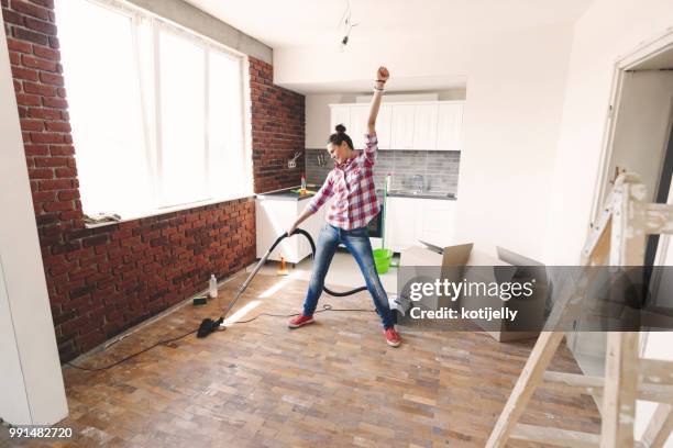 gelukkige vrouw schoonmaken met de stofzuiger van haar nieuwe huis - vacuum cleaner woman stockfoto's en -beelden