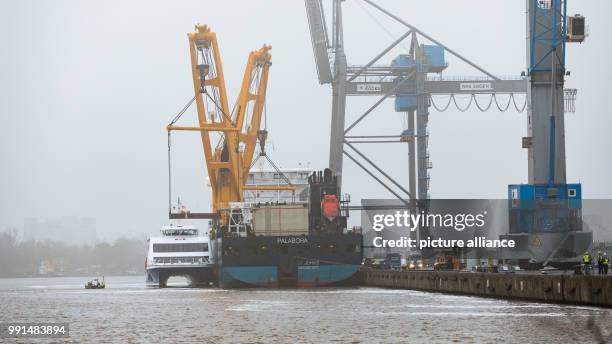 The catamaran "Halunder Jet" floating next to the heavy cargo freighter "Palabora" ahead of its loading in the harbour of Emden, Germany, 15 November...