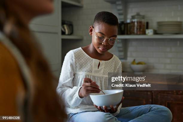 portrait of cute girl eat brakfast out of bowl, with friend - monacle glasses stock-fotos und bilder