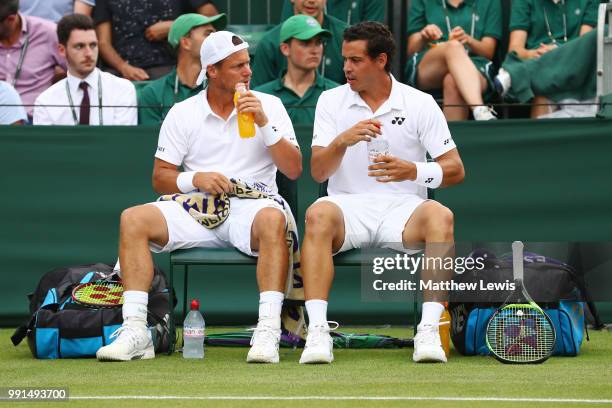 Alex Bolt of Australia and Lleyton Hewitt of Australia talk during a break in their Men's Doubles first round match against Raven Klaasen of South...