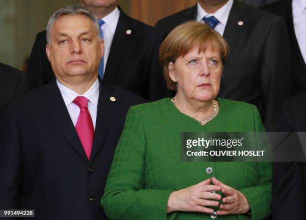 In this file photo taken on February 23, 2018 Hungarian Prime Minister Viktor Orban and German Chancellor Angela Merkel pose for a family photo...