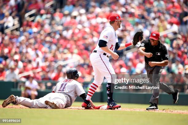 First base umpire Jeremy Rehak calls out Rafael Devers of the Boston Red Soxafter getting picked off at first base by Mark Reynolds of the Washington...