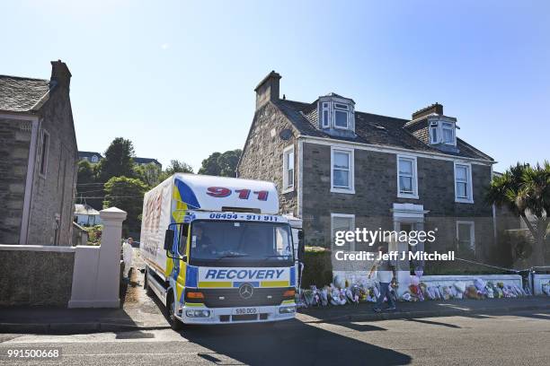 Recovery vehicle remove a dark colored Dacia car from a garden at a house on Ardbeg Road on the Isle of Bute following the conformation that six year...