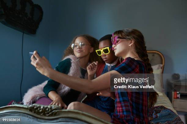girlfriends making selfie and wearing weird, funny glasses - klaus vedfelt stock-fotos und bilder