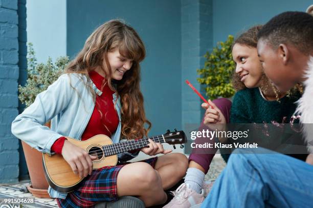 girlfriends practicing ukulele together on the porch - klaus vedfelt fotografías e imágenes de stock
