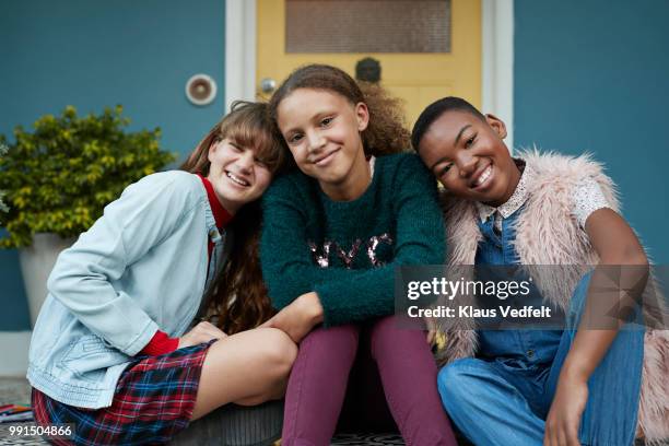 portrait of 3 happy girlfriends, relaxing on porch - klaus vedfelt stock-fotos und bilder