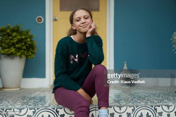 Portrait of young girl sitting on porch