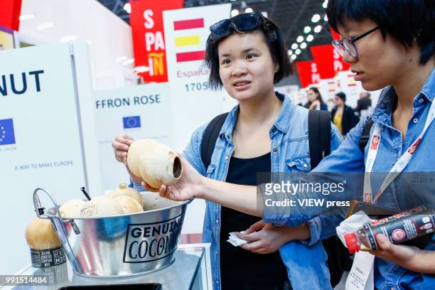 Women look at coconuts during The Summer Fancy Food Show at the Javits Center in the borough of Manhattan on July 02, 2018 in New York, The Summer...